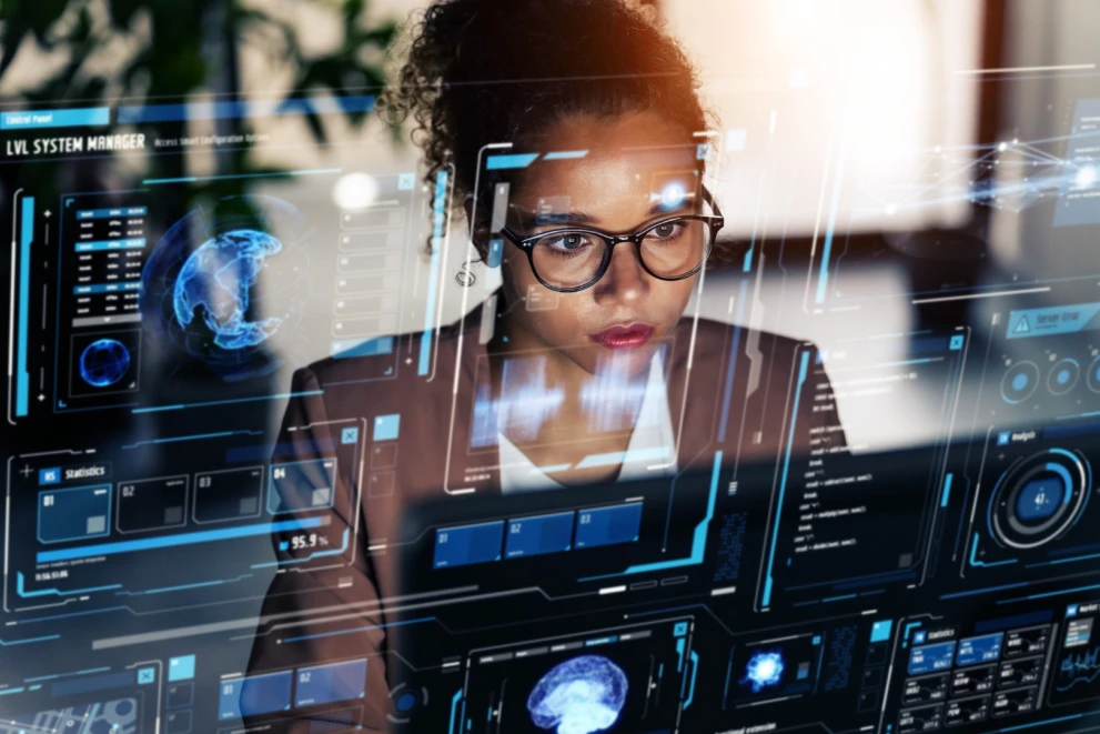 Das Bild zeigt eine Security-Analystin vor einem digitalen SOC-Dashboard mit Monitoring- und Analyse-Overlays. Es passt zu Themen wie KI in der Cybersecurity, Threat Detection, SIEM/Monitoring und automatisierte Incident Response im Enterprise-Umfeld.