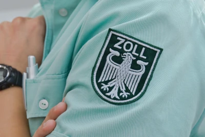 The image shows the insignia of the German customs administration on a uniform. It represents Digital Customs Day 2026, focusing on digital transformation, artificial intelligence, modern IT infrastructures and innovative administrative processes within customs and public administration. ISO-Gruppe presents digital solutions for future-ready government services.