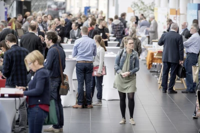 Das Bild zeigt die Networking-Atmosphäre auf einem Fundraising-Kongress mit vielen Teilnehmenden im Austausch an Stehtischen und Infopoints. Es visualisiert den 14. Fundraisingtag in Gelsenkirchen am 29. April 2026, bei dem Vereine und Stiftungen Praxiswissen zu Spenden, Unternehmenskooperationen und Stiftungen teilen. Die ISO-Gruppe ist mit Charity:up vor Ort und präsentiert personalisierte Videos, die Spenden oder Newsletter-Abos direkt im Video auslösen – ohne Medienbrüche.