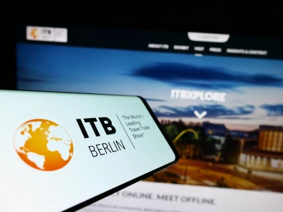 The image shows ITB Berlin branding displayed on a mobile device in front of a digital exhibition backdrop. It represents ITB Berlin 2026 and the presence of ISO-Gruppe’s Travel division. At the event, ISO-Gruppe showcases Travel IT solutions and engages with international industry professionals on digital innovation in tourism.