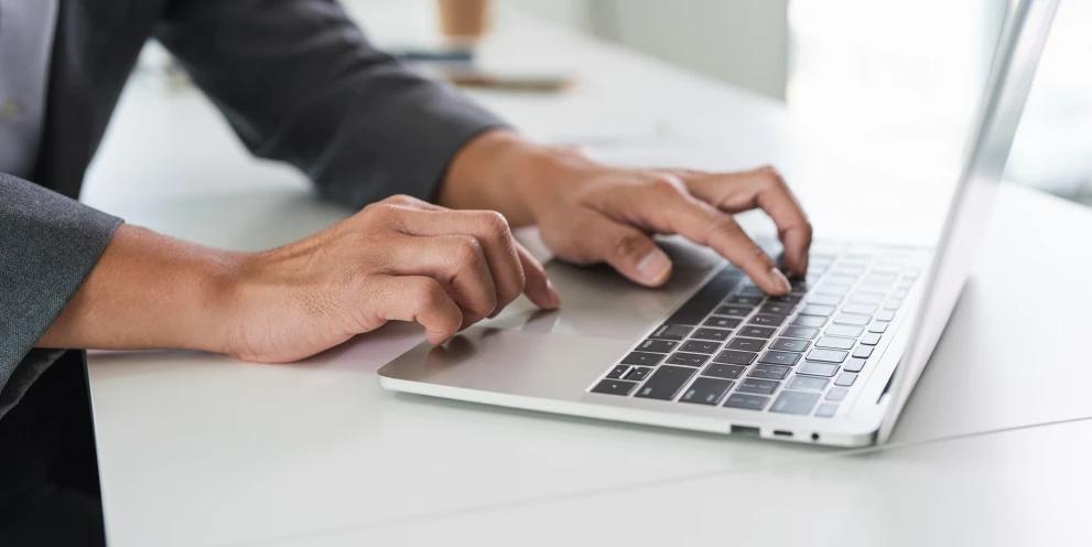 Person arbeitet an einem Laptop als Symbol für Analyse, Dokumentation und Steuerung von IT-Security-Aufgaben.