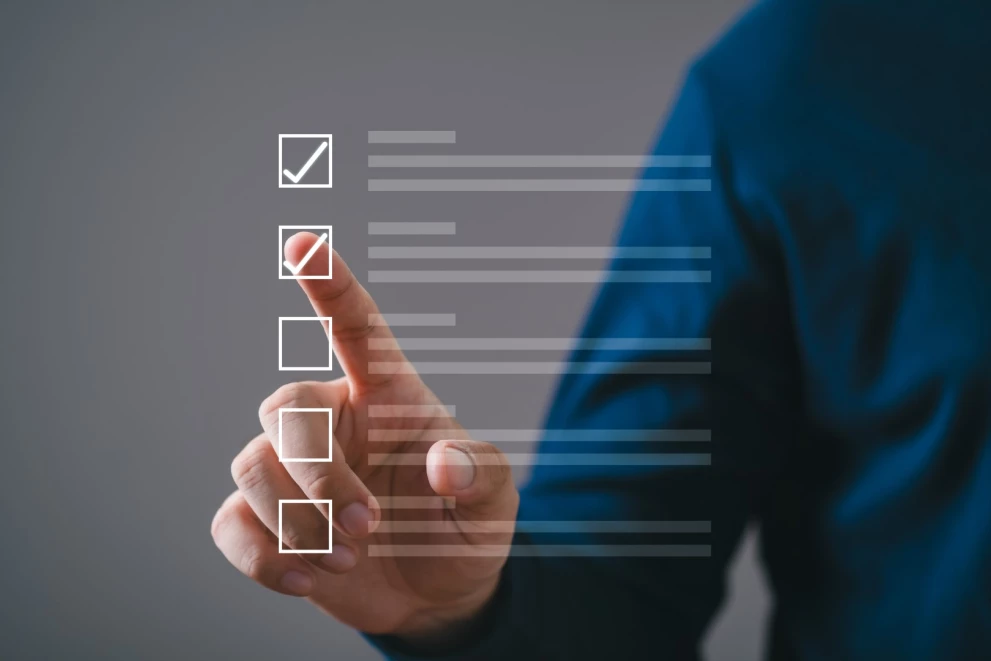 Finger pointing at a digital checklist with multiple checkboxes – visual representation of preparation for a training at ISO-Gruppe.