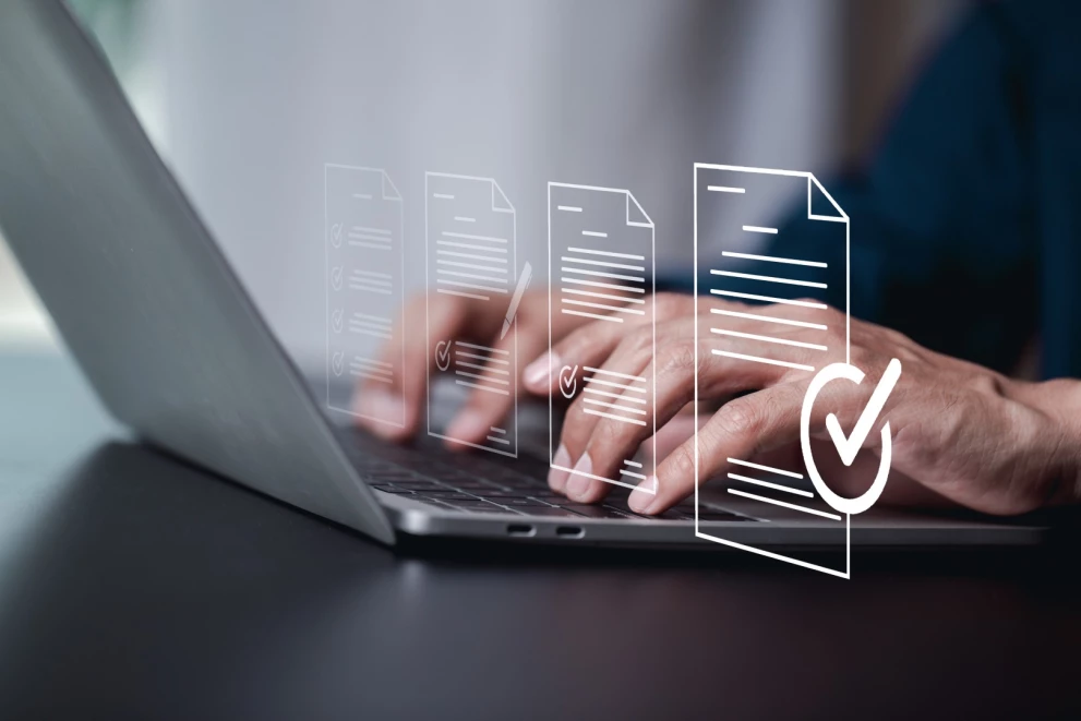  Hands working on a laptop with visual icons for document approval