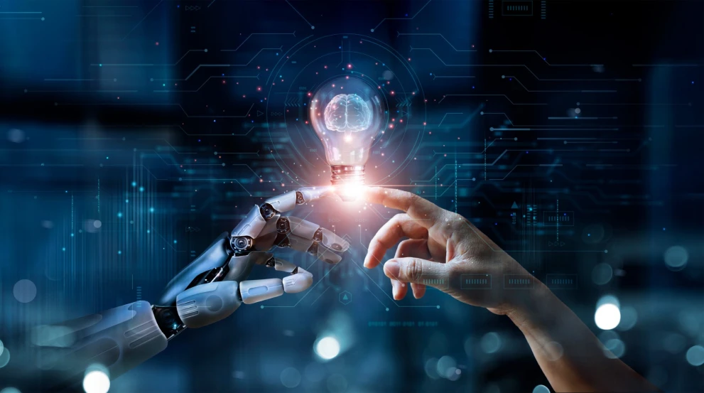 Eine menschliche und eine robotische Hand berühren ein Symbol für „Idee“ und Prozessstart – passend für automatisiertes Onboarding. Das Motiv eignet sich für Inhalte zu KI-gestützten Workflows, User Activation, Self-Service, Account-Provisioning und standardisierten Onboarding-Prozessen im B2B.