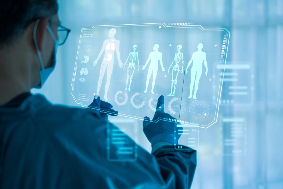 Ein Arzt analysiert ein digitales Diagnostik-Display mit Körper- und Scan-Visualisierungen als Sinnbild für KI in der medizinischen Bildanalyse. Das Motiv passt zu Tumorerkennung, Radiologie-Workflows, Clinical Decision Support und der Auswertung von Bilddaten mit Machine Learning.